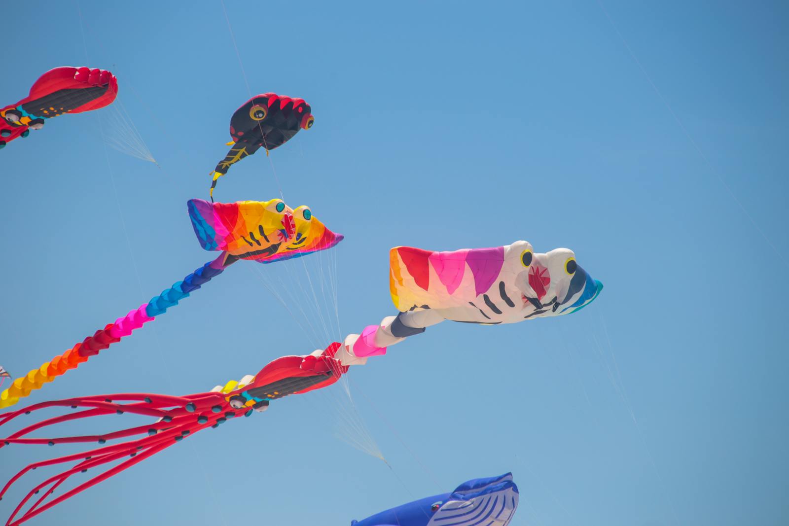 Kite Sail Repair: Blue and yellow kite flying in clear blue sky, symbolizing kite sail repair and sustainable outdoor sports