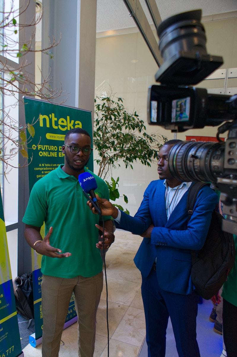 Nation Media Rwanda: a man in a green shirt talking to a man in a blue suit